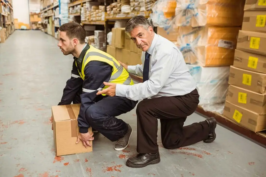 Manager training worker for health and safety measure relating to lifting boxes safely